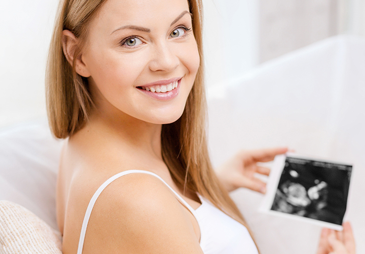 happy pregnant woman with ultrasound picture
